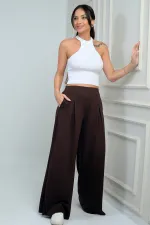 Pantalon Osyho pour femme, jambes larges, taille élastique, poches et plis sur le devant.
