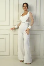 Combinaison palazzo pour femme avec encolure en cœur, ceinture à la taille, manches en tulle et détails carrés à paillettes.