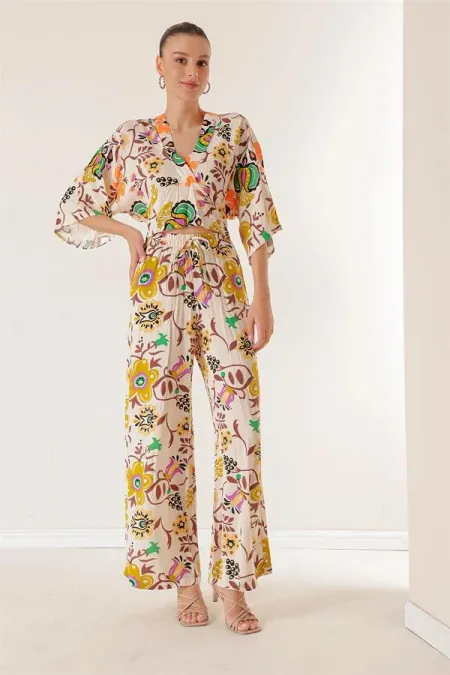 Ensemble deux pièces : pantalon palazzo à taille élastique, poches, col en V devant et dos, crop top à motif floral.