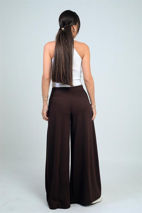 Pantalon Osyho pour femme, jambes larges, taille élastique, poches et plis sur le devant.