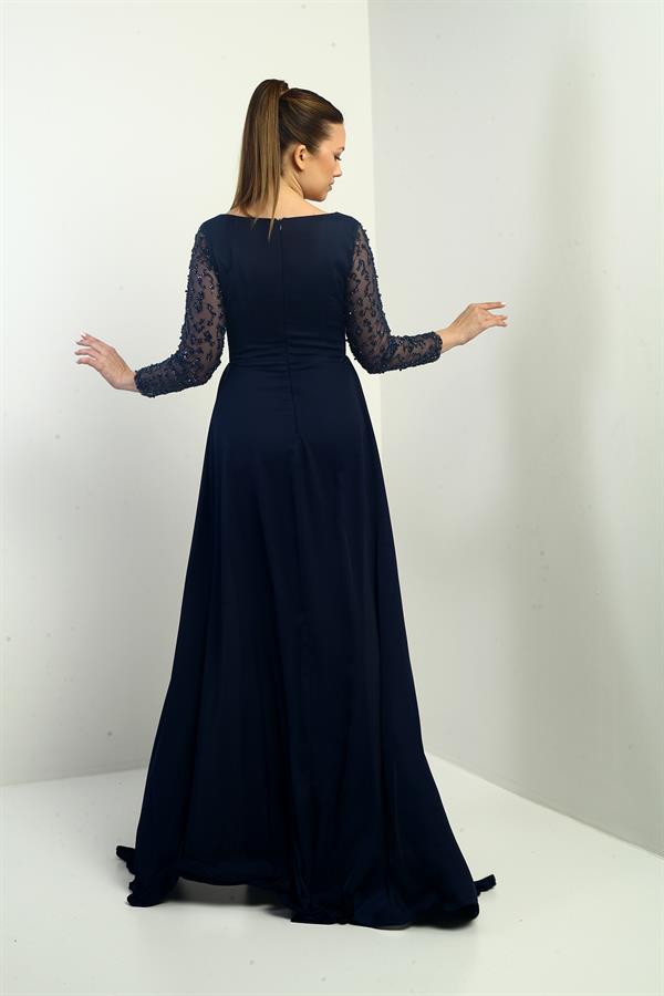 Robe de soirée longue en crêpe satin, doublée, à col carré et manches perlées, coupe ample.