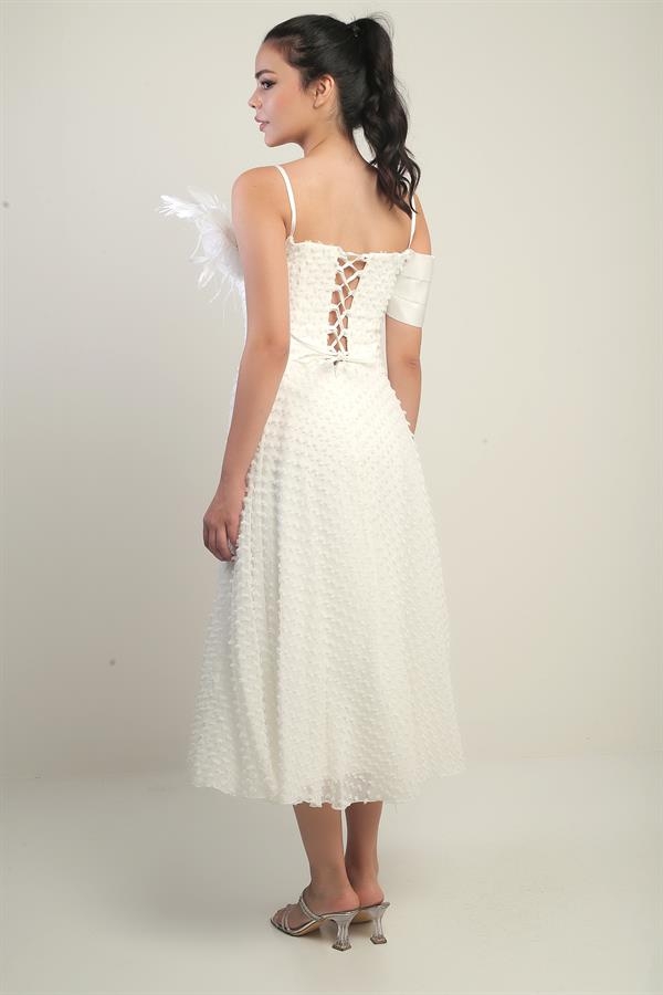 Robe à bretelles croisées dans le dos, lacée, à une manche tombante, ornée d'une broche en plumes et doublée en tissu brillant.