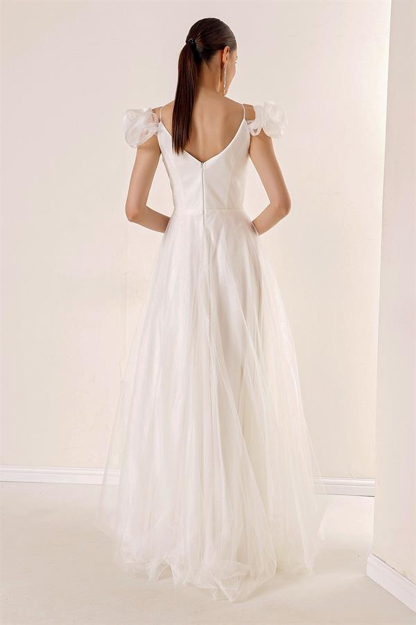 Robe longue en tulle doublée, décolleté en V devant et dos, bretelles spaghetti, manches tombantes, détail en pierre sur le devant.