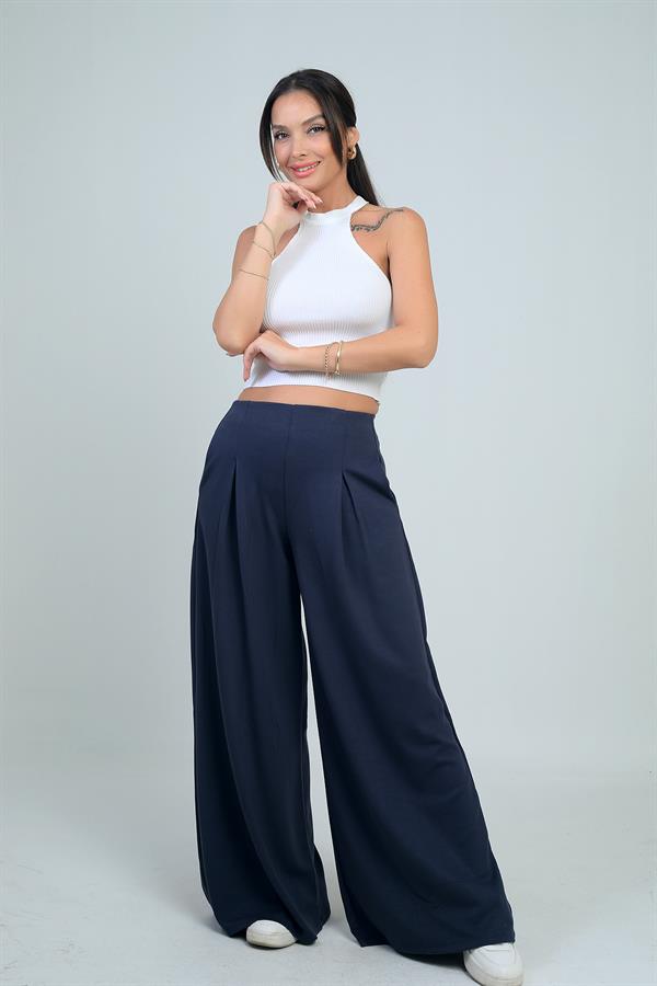 Pantalon Osyho pour femme, jambes larges, taille élastique, poches et plis sur le devant.