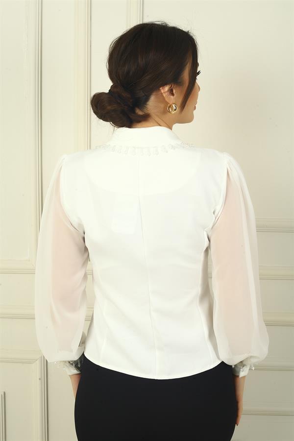 Chemisier cache-cœur en mousseline à manches longues, orné de perles et fermé par des boutons.