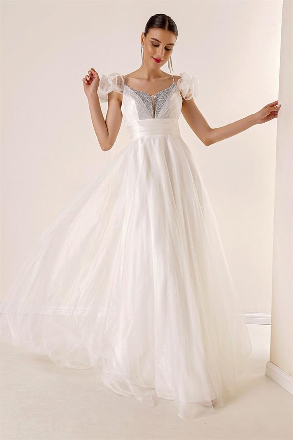 Robe longue en tulle doublée, décolleté en V devant et dos, bretelles spaghetti, manches tombantes, détail en pierre sur le devant.