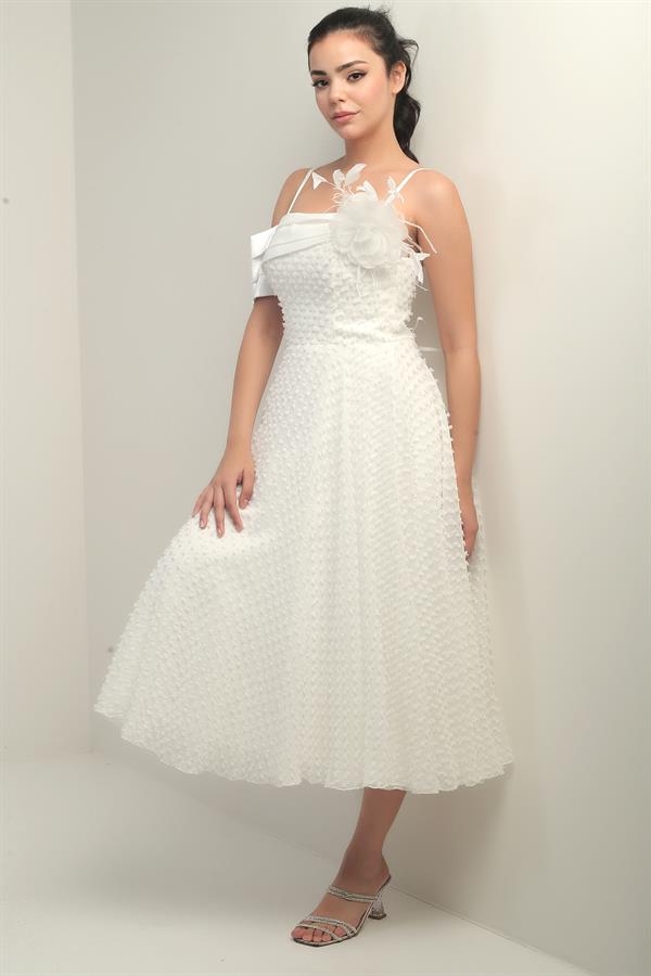 Robe à bretelles croisées dans le dos, lacée, à une manche tombante, ornée d'une broche en plumes et doublée en tissu brillant.