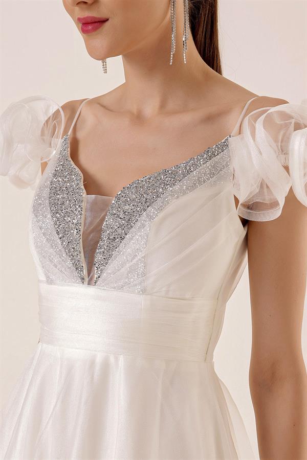 Robe longue en tulle doublée, décolleté en V devant et dos, bretelles spaghetti, manches tombantes, détail en pierre sur le devant.