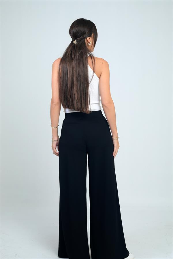 Pantalon Osyho pour femme, jambes larges, taille élastique, poches et plis sur le devant.