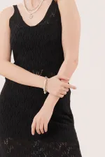 Robe noire ajourée à col en V et détails à pompons