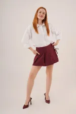 Mini-jupe courte bordeaux en gros avec devant plissé et détails de cravate sur le côté
