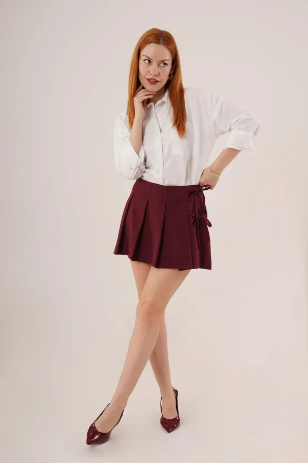 Mini-jupe courte bordeaux en gros avec devant plissé et détails de cravate sur le côté