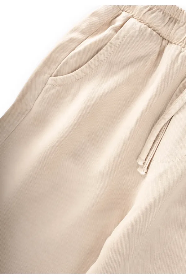 Loose-fitting girls' trousers, ages 2-12, beige. Loose-fitting girls' trousers, ages 2-12, beige.