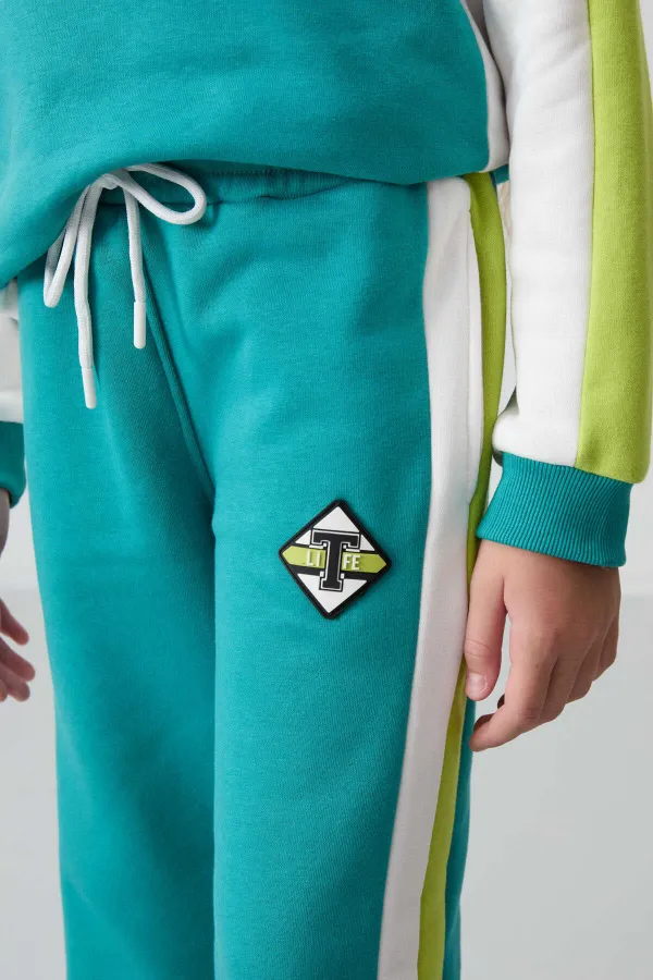 Ensemble de survêtement Tommylife Wholesale pour filles de 7 à 15 ans, col rond, coupe standard, réf. 75165, bleu marine et vert.